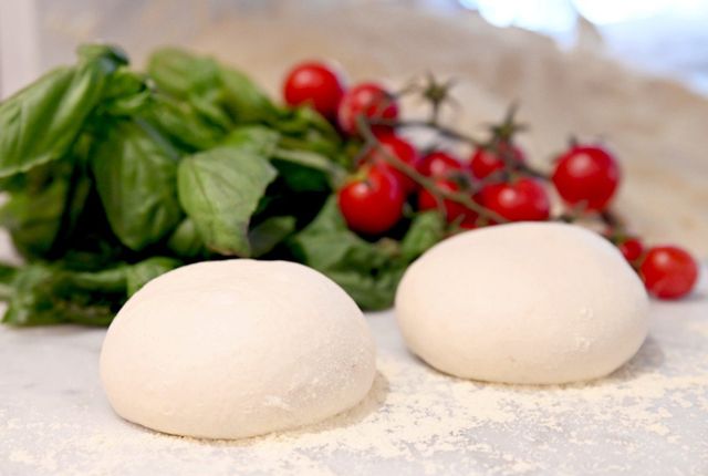 Due palline di pasta con basilico e pomodorini.