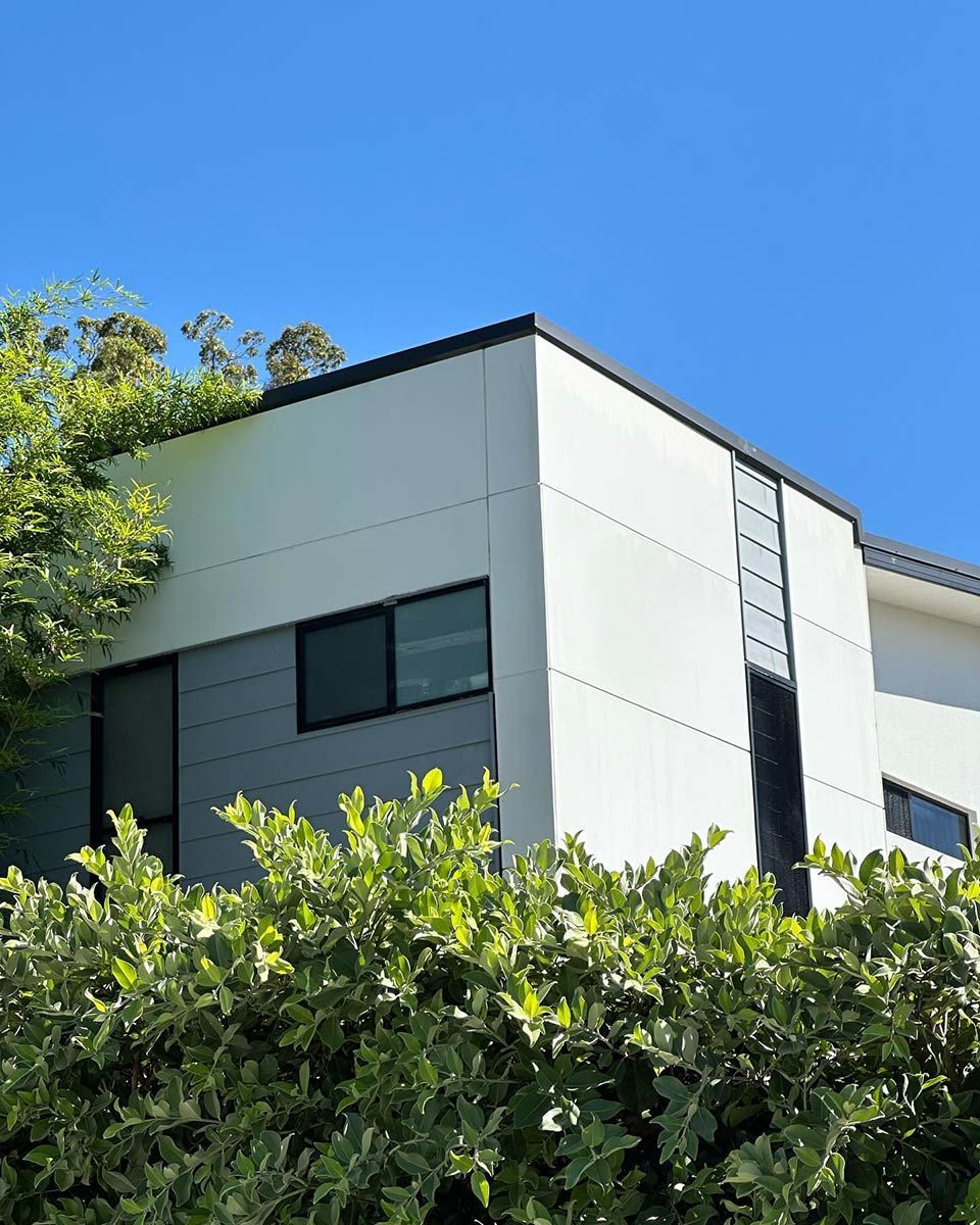 A White And Gray Building With A Blue Sky In The Background — Clean Cartel Pressure Washing In Brisbane, QLD