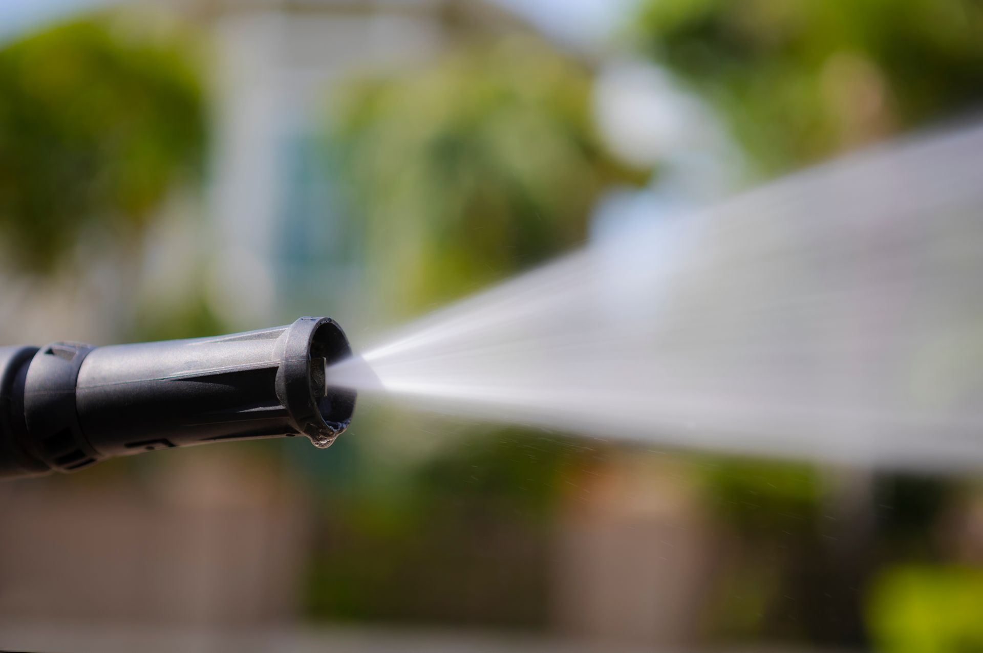 Un gros plan d'un nettoyeur haute pression pulvérisant de l'eau.