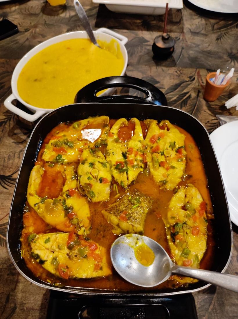 Uma fila de buffet em um restaurante com tigelas de comida em uma prateleira.