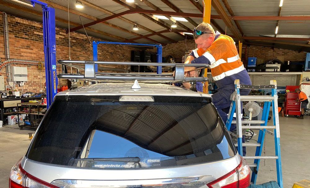 Man Fixing The Top Of The Car — Towing Service In Narromine, NSW