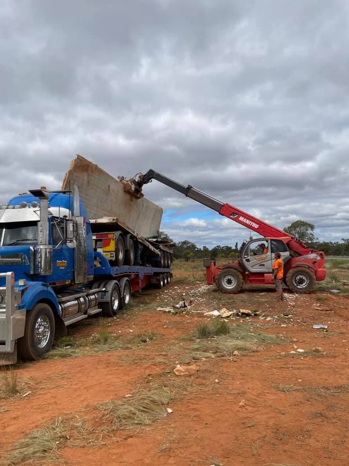 Red Truck Loading Pile Of Debris On Tow Truck — Towing Service In Gilgandra, NSW