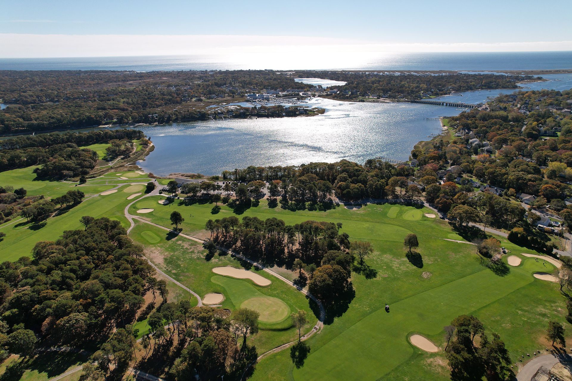 An aerial view of a golf course with a lake in the background
