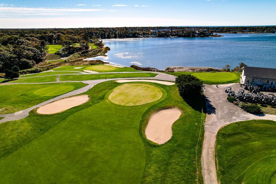 An aerial view of a golf course next to a body of water.