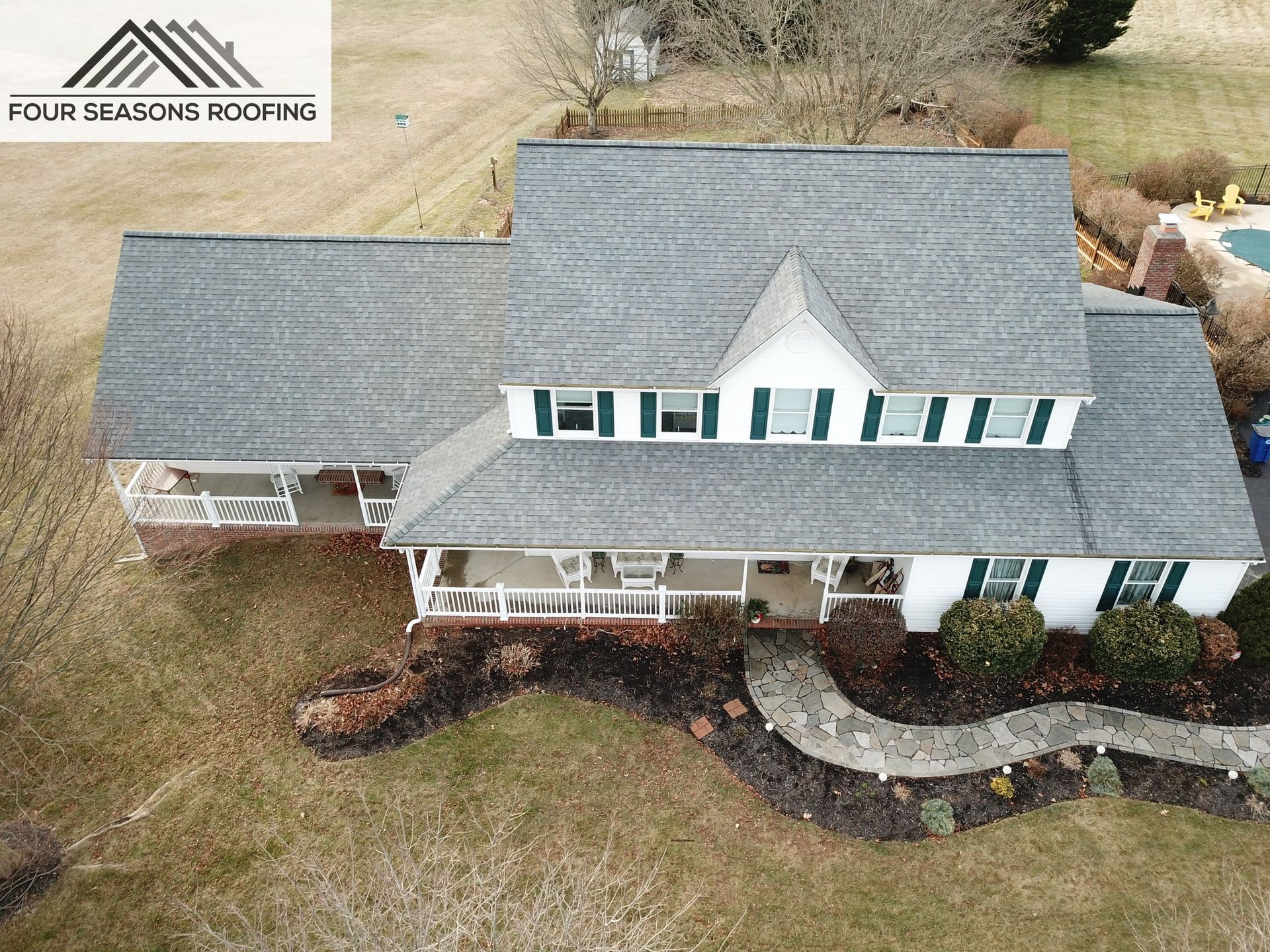 An aerial view of a large white house with a gray roof in Maryland