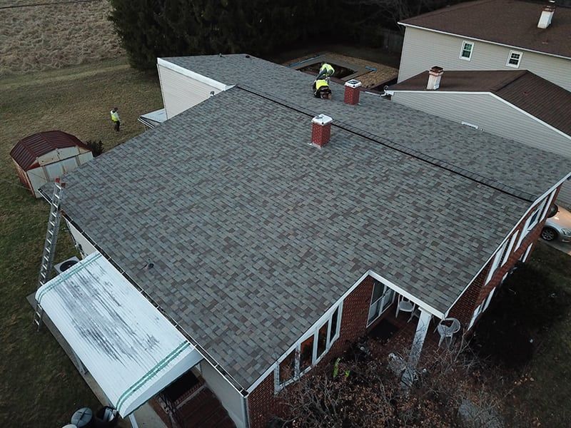 An aerial view of a house with a new roof being installed.