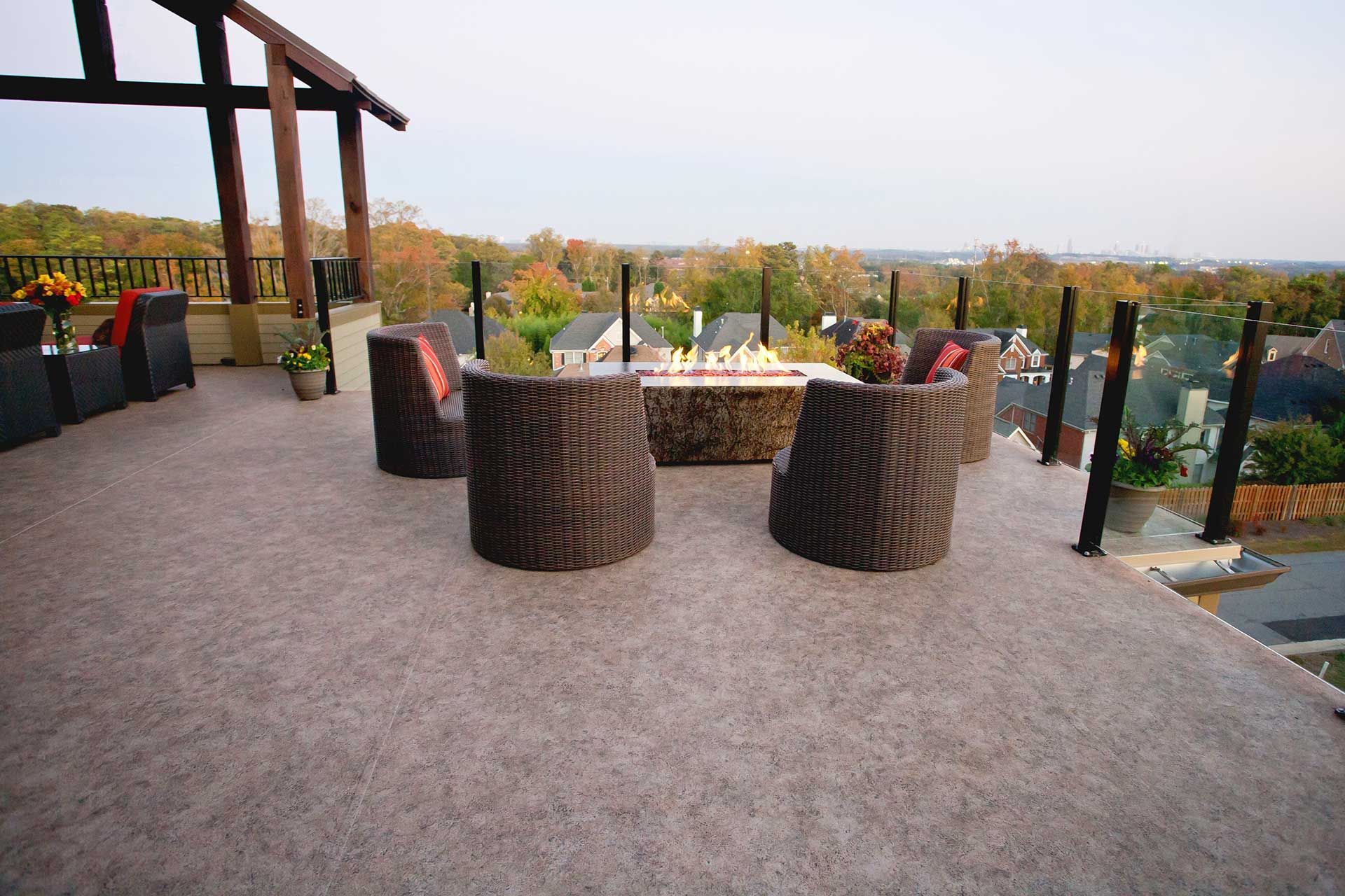 A patio with a fire pit and chairs on it