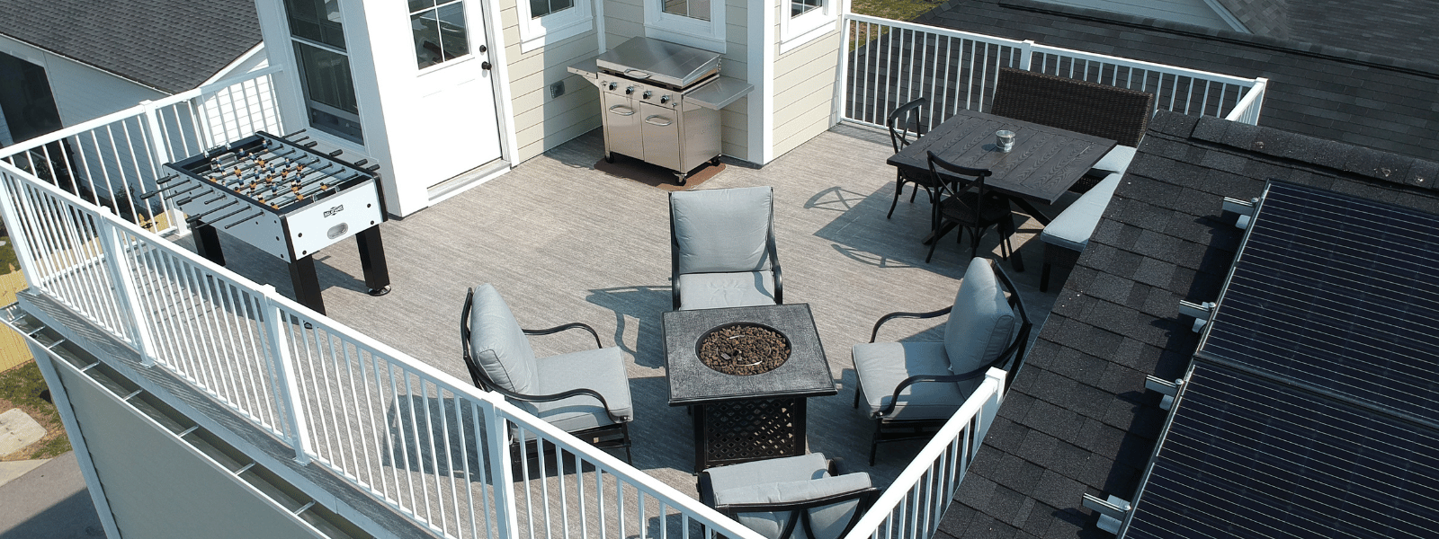 An aerial view of a rooftop deck with a table and chairs.