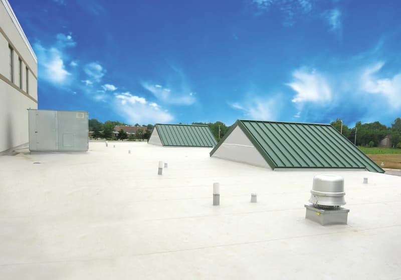 A white roof with a green roof and a fan on it