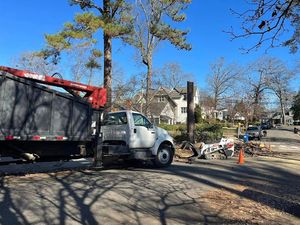 A stump grinder is being used to remove a tree stump from a driveway.