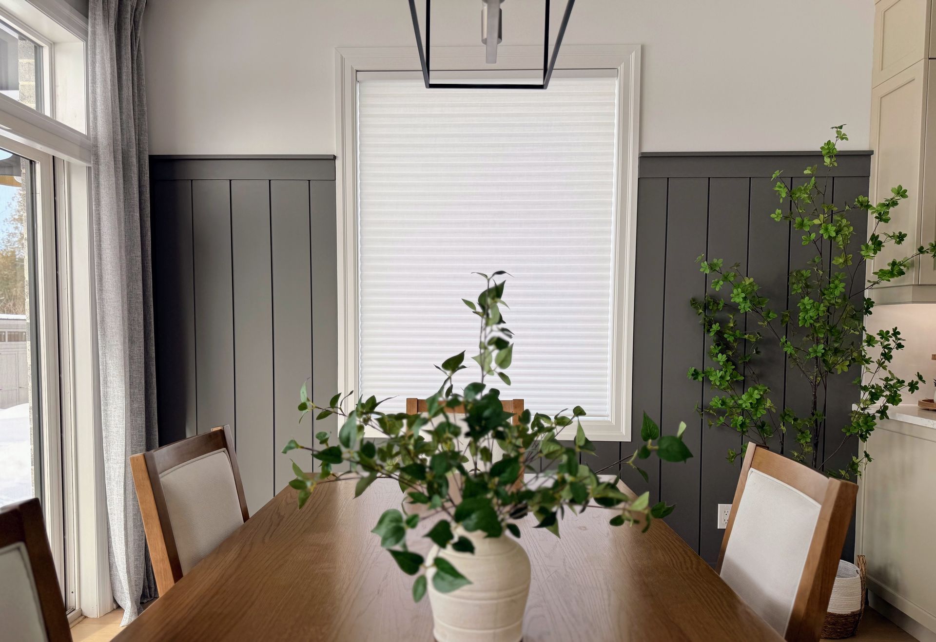 Dining room with half wall paneling and greenery