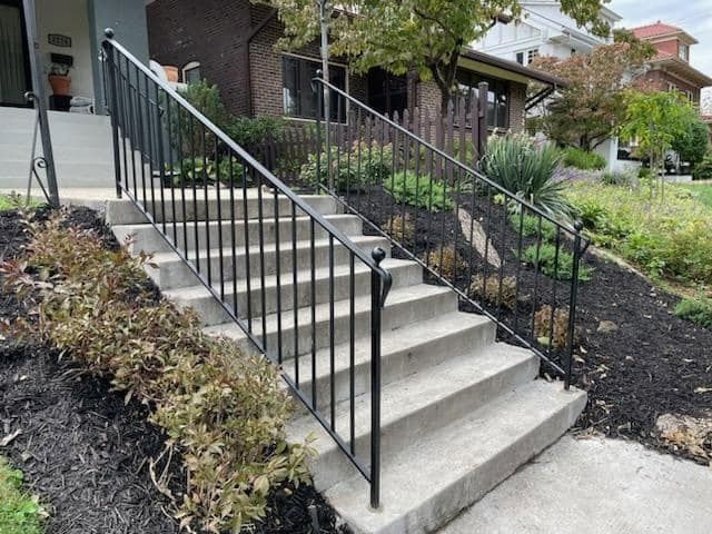 A set of stairs with a metal railing leading up to a house
