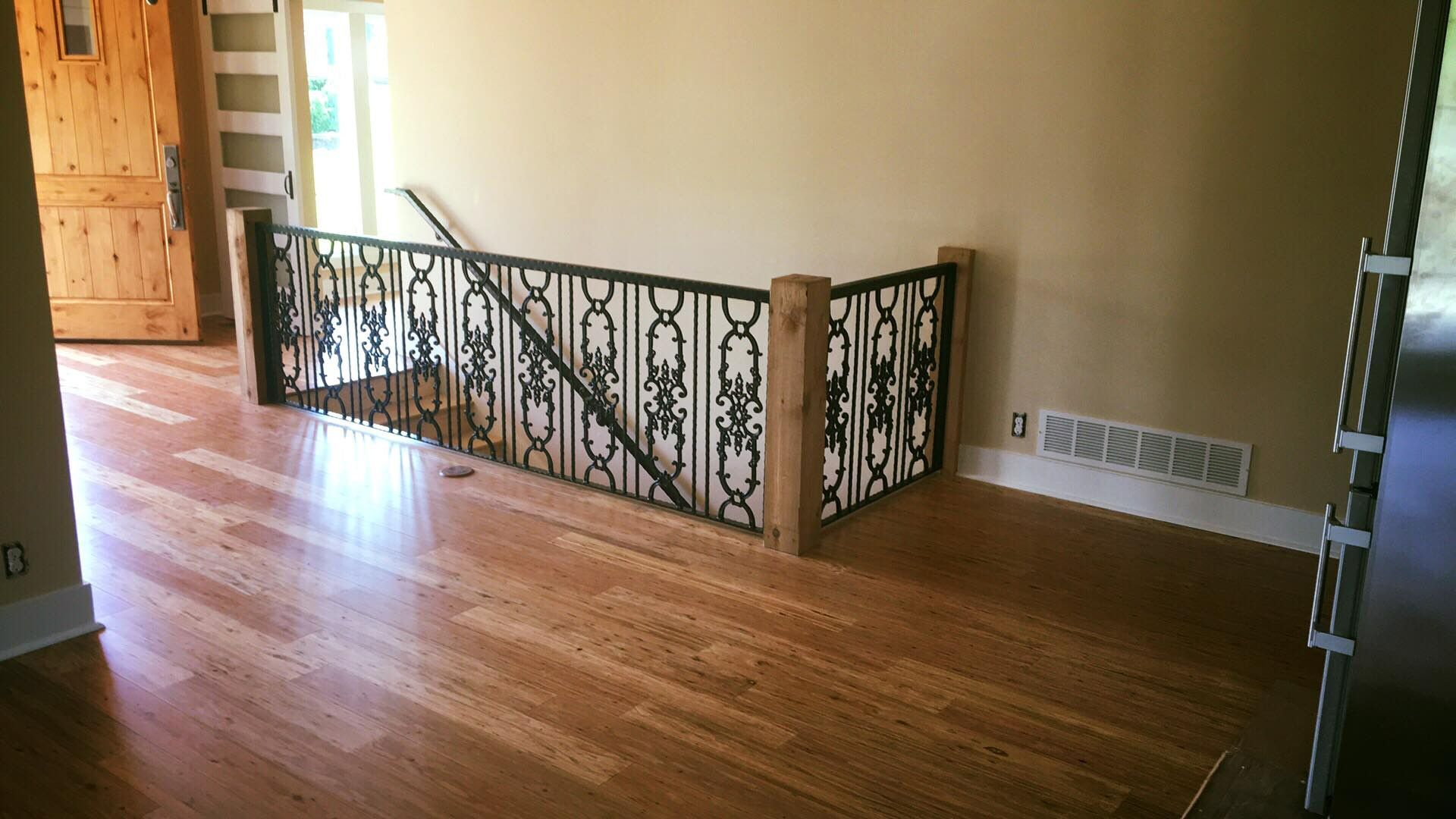 A staircase with a wrought iron railing in the middle of the room