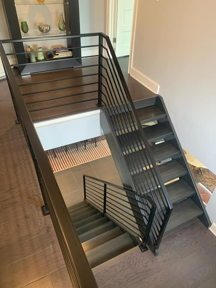 A black staircase with a black railing in a house