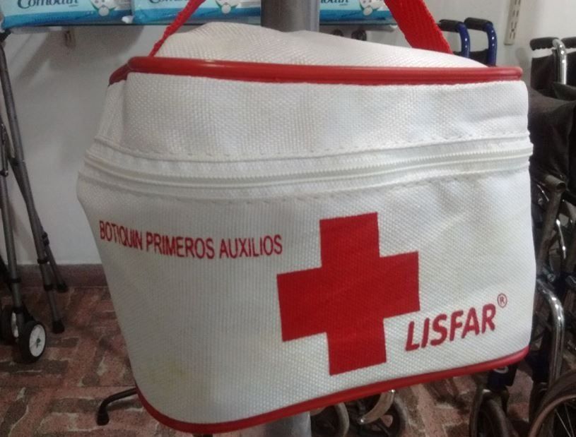 Botiquín blanco de primeros auxilios con cruz roja y el texto “LISFAR”, etiquetado como “Botiquín primeros auxilios”.