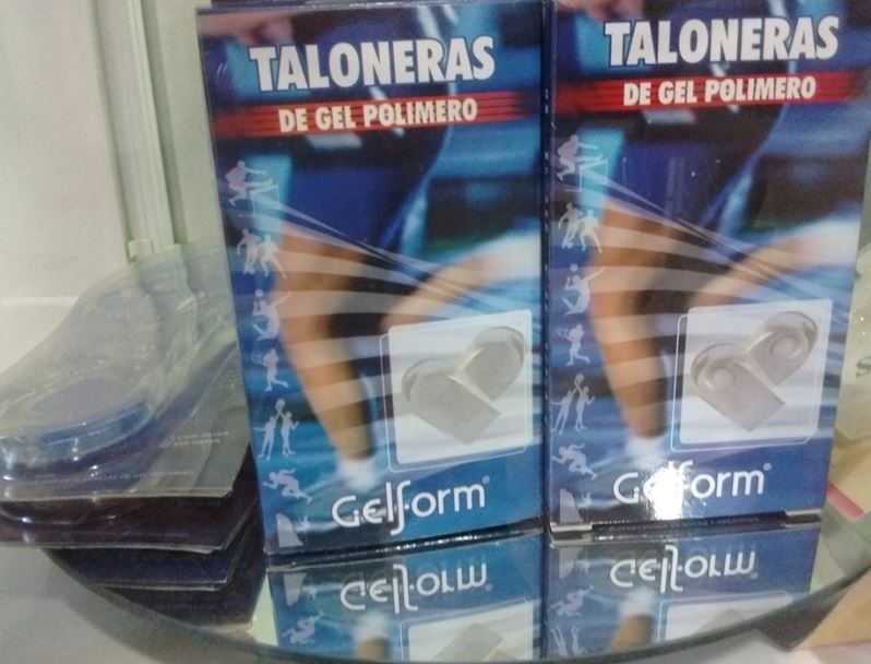 Cajas de almohadillas de gel polimérico para el talón en un estante de una tienda, con empaques azules