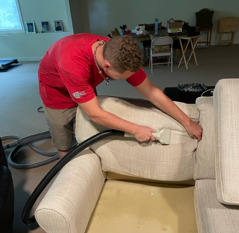 Upholstery cleaning worker steam cleaning an upholstered chair 