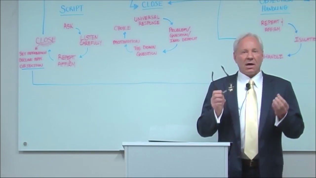 Man gesturing in front of a whiteboard with handwritten business process steps.