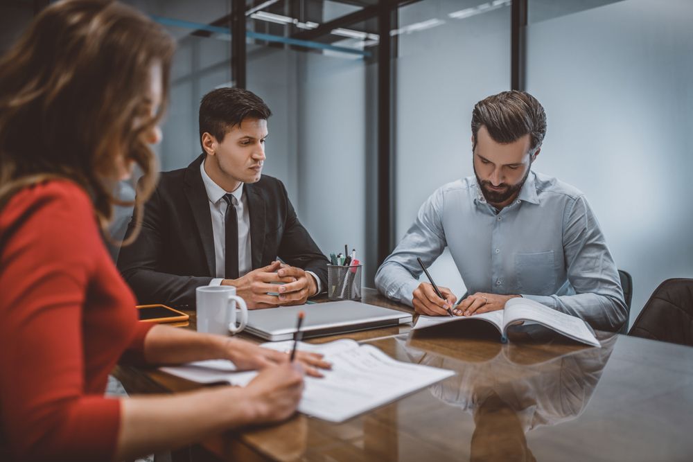 A Group Of People Are Sitting At A Table Having A Meeting — Charlestown Law Firm In Charlestown, NSW
