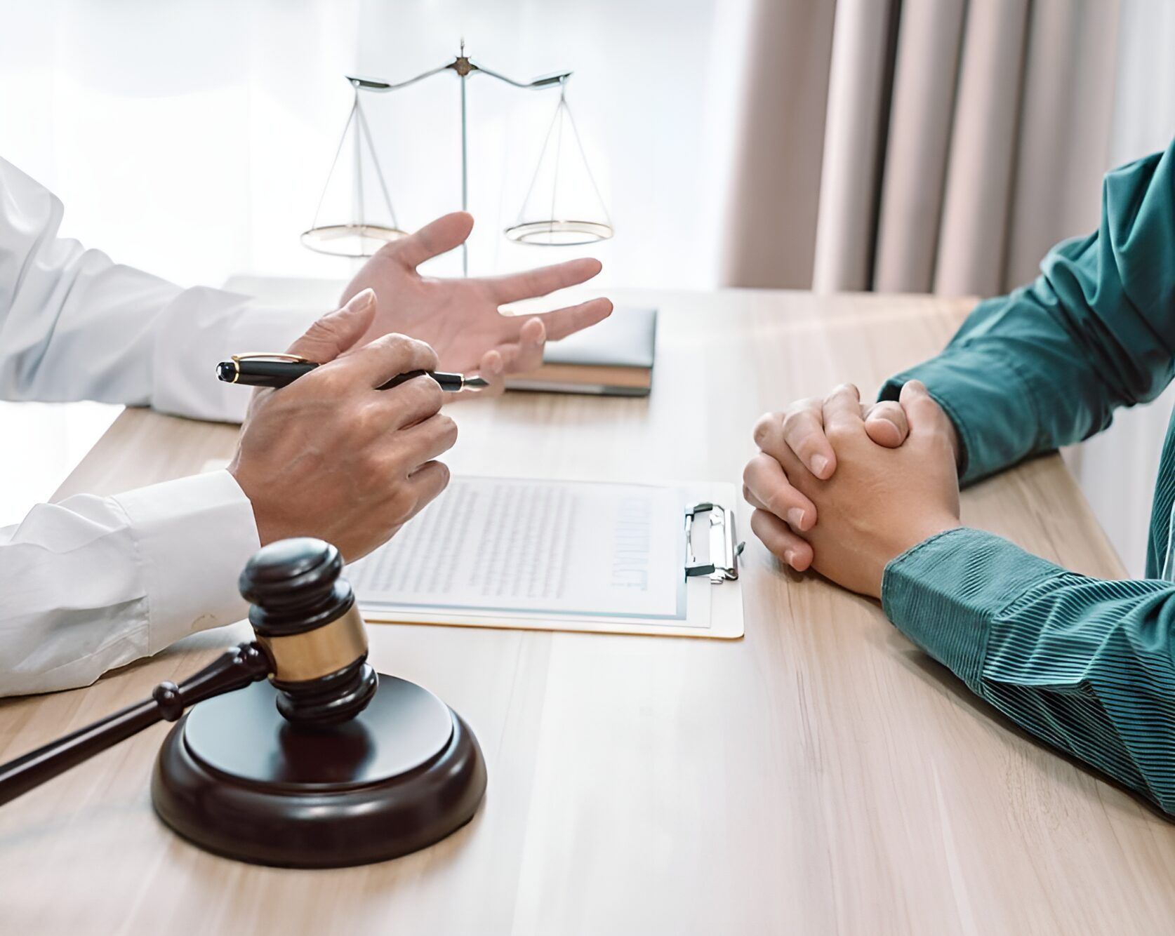 A Lawyer Is Talking To A Client At A Table With A Gavel And Scales Of Justice — Charlestown Law Firm In Charlestown, NSW
