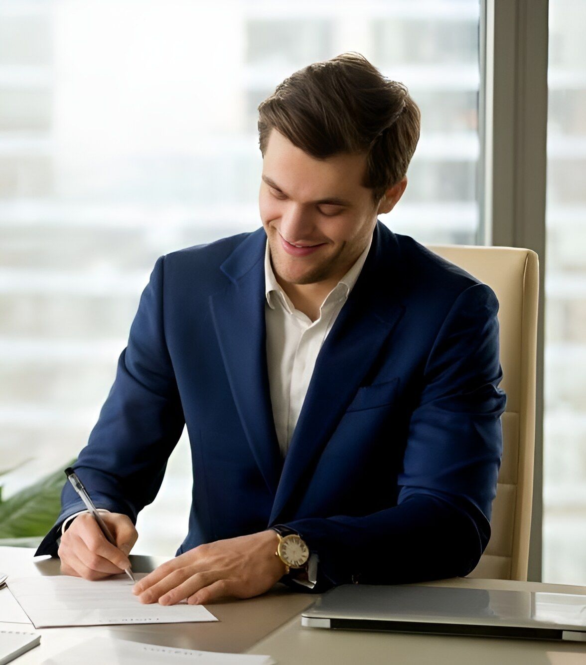 A Man In A Suit Is Sitting At A Desk Writing On A Piece Of Paper — Charlestown Law Firm In Charlestown, NSW