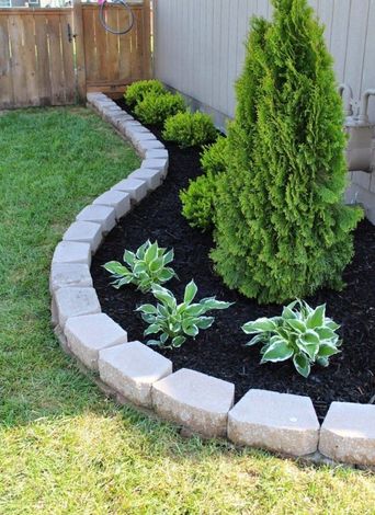 A garden with a brick border and plants in it