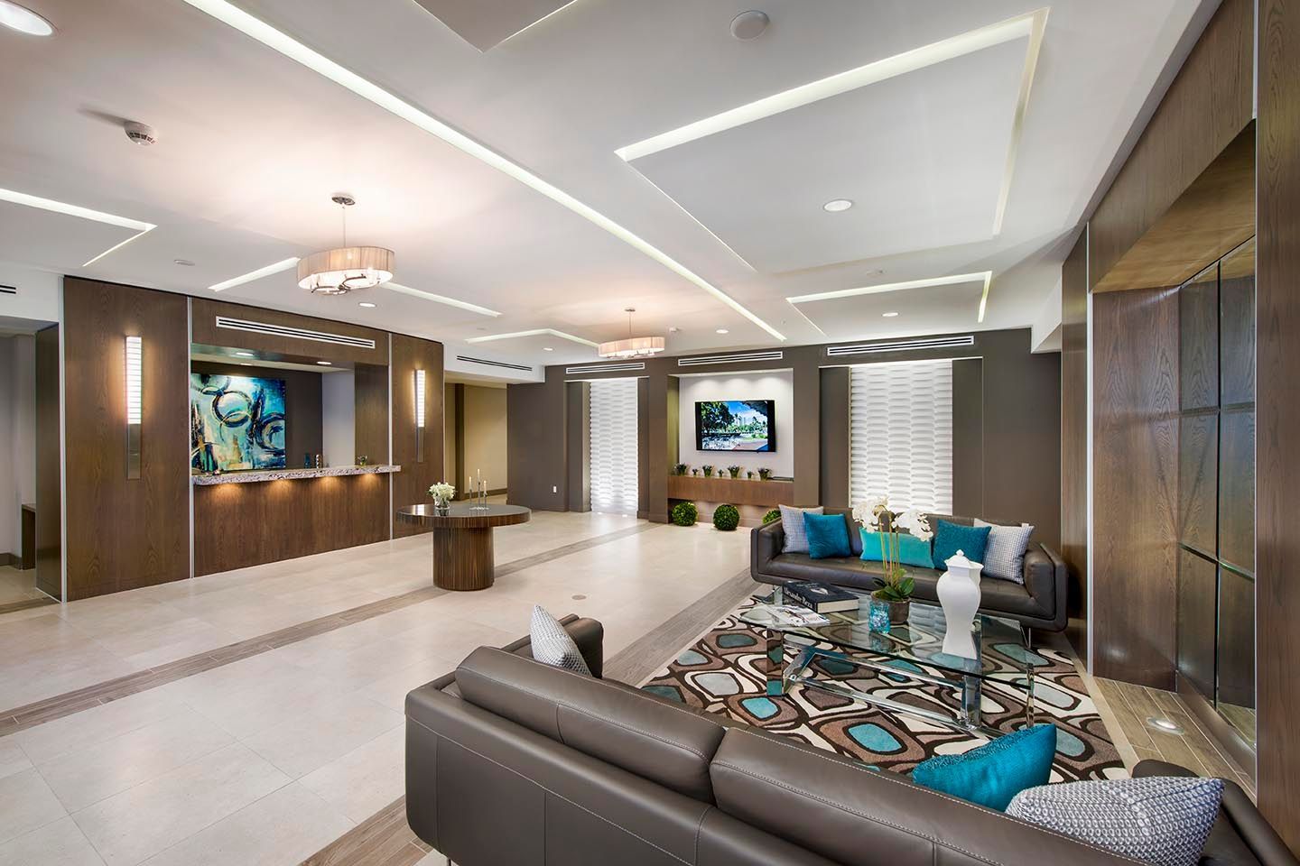 Hotel lobby with reception desk, sofas, and decorative lighting.