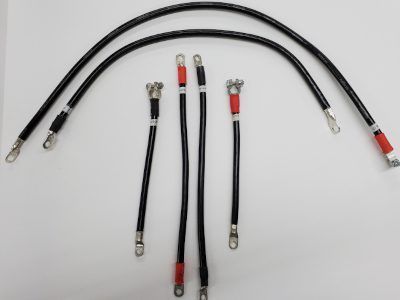 Close-up of a car starter motor with red and black cables attached in an engine bay
