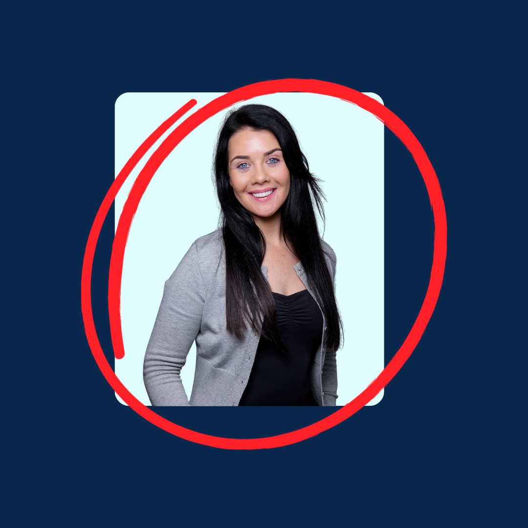 Smiling woman in a gray cardigan and black top on a light blue background