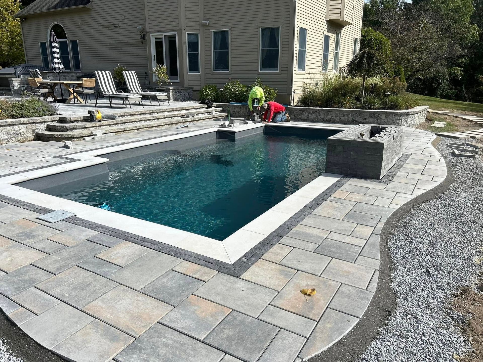 A large swimming pool is being built in front of a house.
