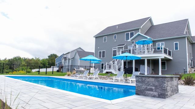 A large house with a large swimming pool in front of it.