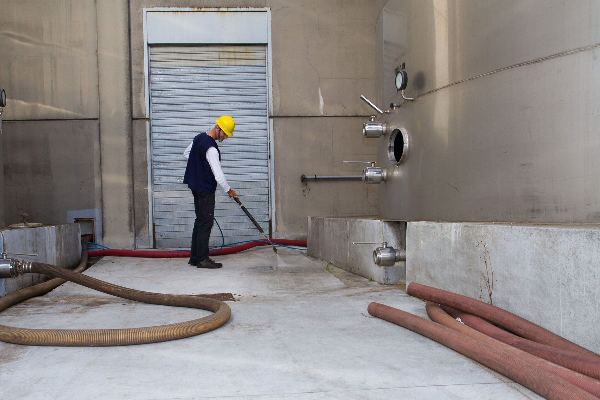A man is cleaning the floor of a building with a vacuum cleaner.