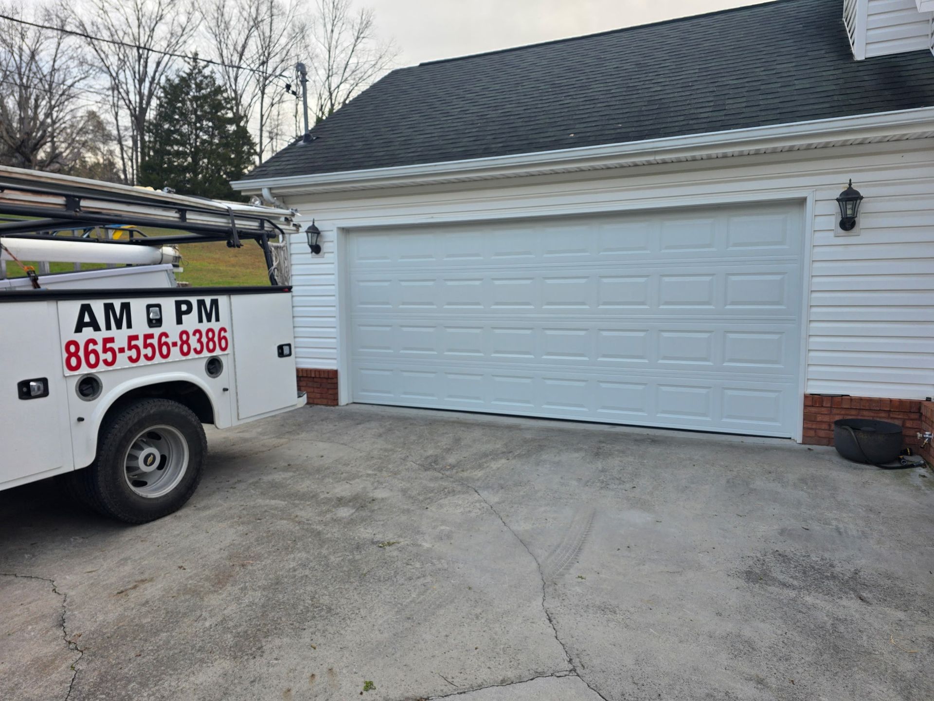 White garage door on a house with a work truck parked in the driveway.