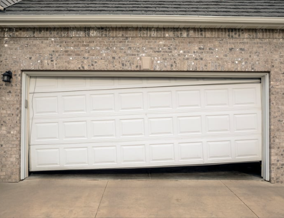 White garage door with a slight bottom gap in a brick house driveway