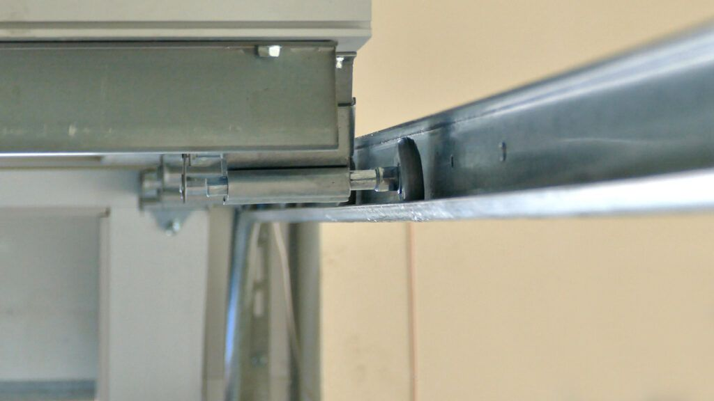 Metal drawer slide and hinge close-up under a cabinet