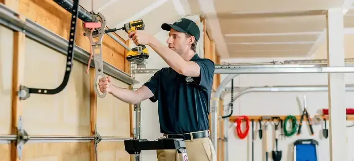 Person installing shelving in a garage workshop with tools and organized storage boxes