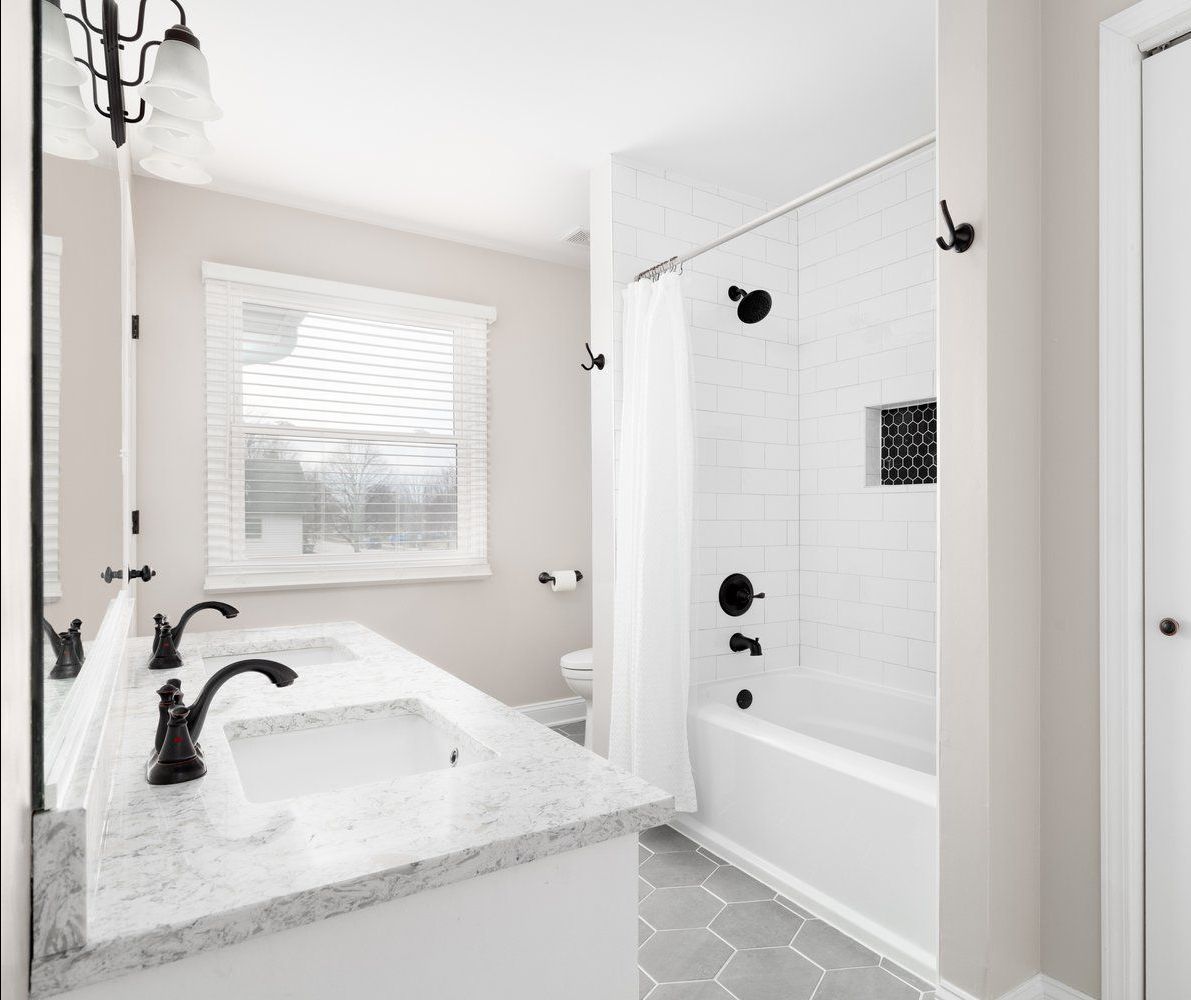 A bathroom with two sinks , a toilet , and a bathtub.