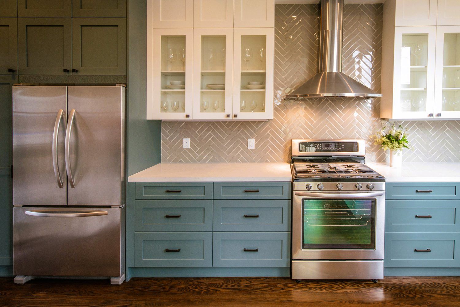 A kitchen with stainless steel appliances and blue cabinets.