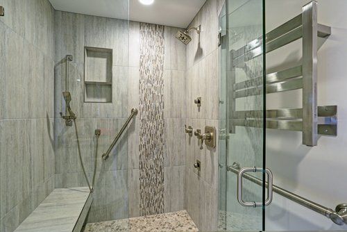 A bathroom with a walk in shower and a bench.