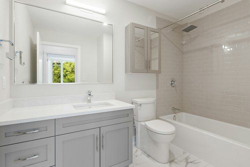 A bathroom with a sink , toilet , tub and mirror.