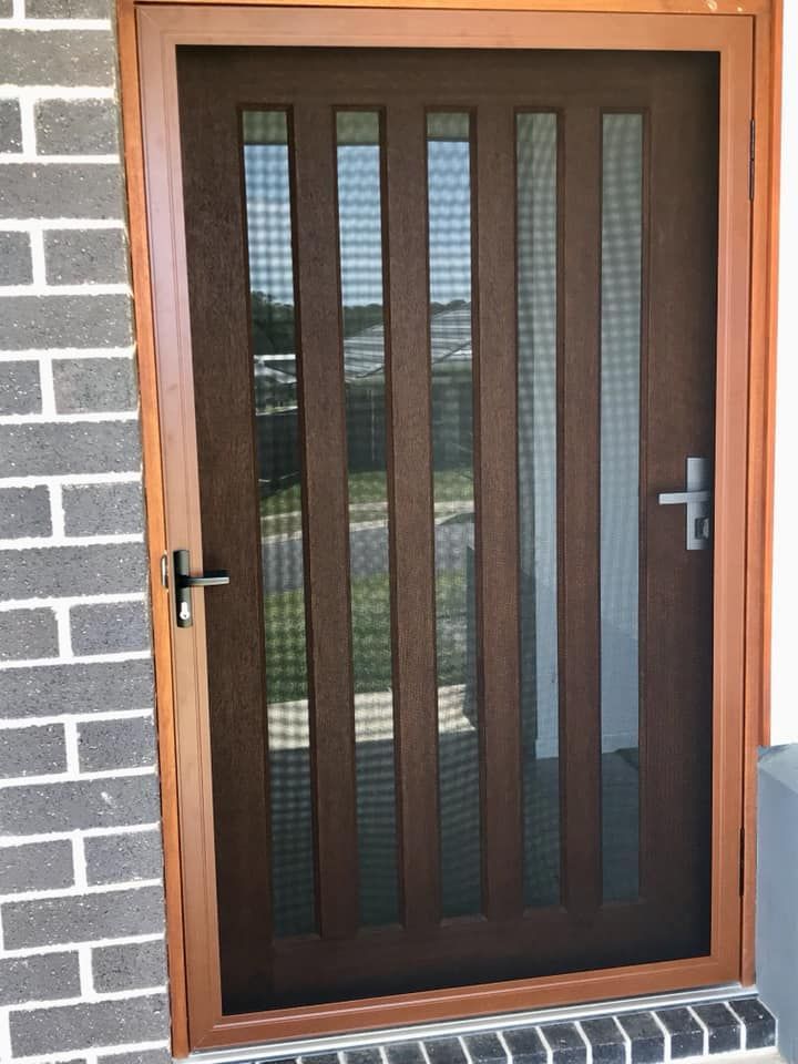 A Wooden Door With a Screen on It is on a Brick Wall β Swift Glass & Aluminium In Woolgoolga, NSW
