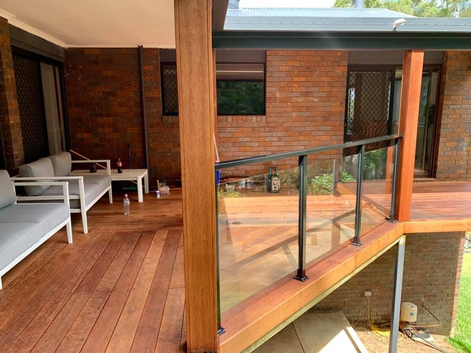 A Wooden Deck With a Glass Railing in Front of a Brick House β Swift Glass & Aluminium In Woolgoolga, NSW