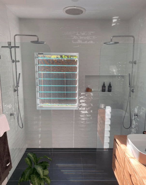 A Bathroom With Two Showers, a Sink and a Window — Swift Glass & Aluminium In Woolgoolga, NSW