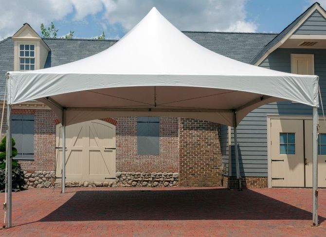 White canopy tent in front of a brick building over a red paved entranceway