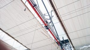 Tubi rossi e grigi a soffitto con cablaggio in un interno in stile industriale.