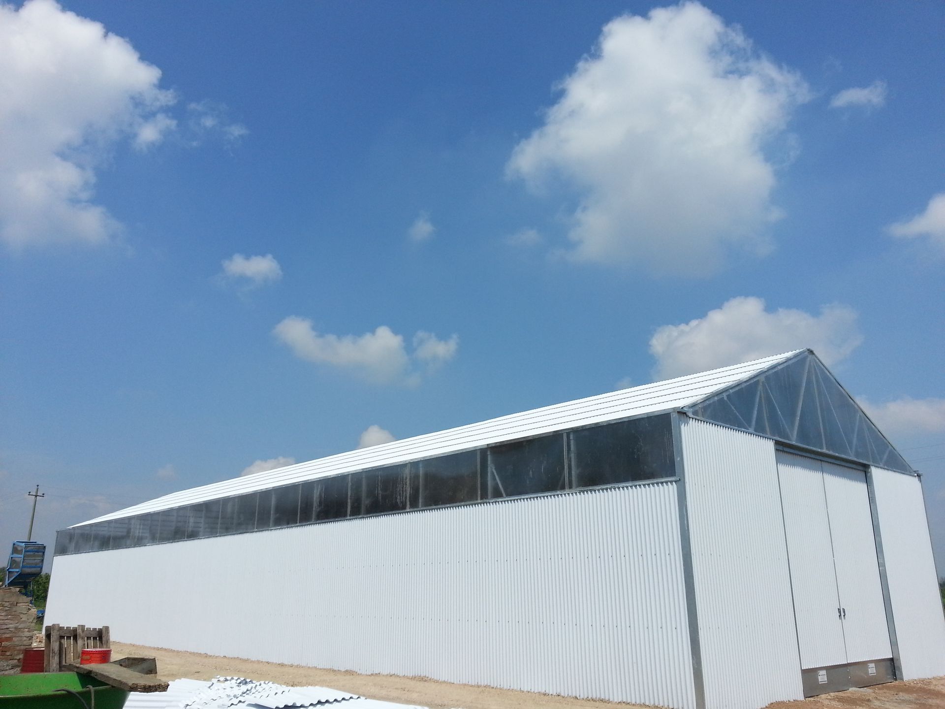 Lungo edificio temporaneo bianco o tenda sotto un cielo azzurro con nuvole