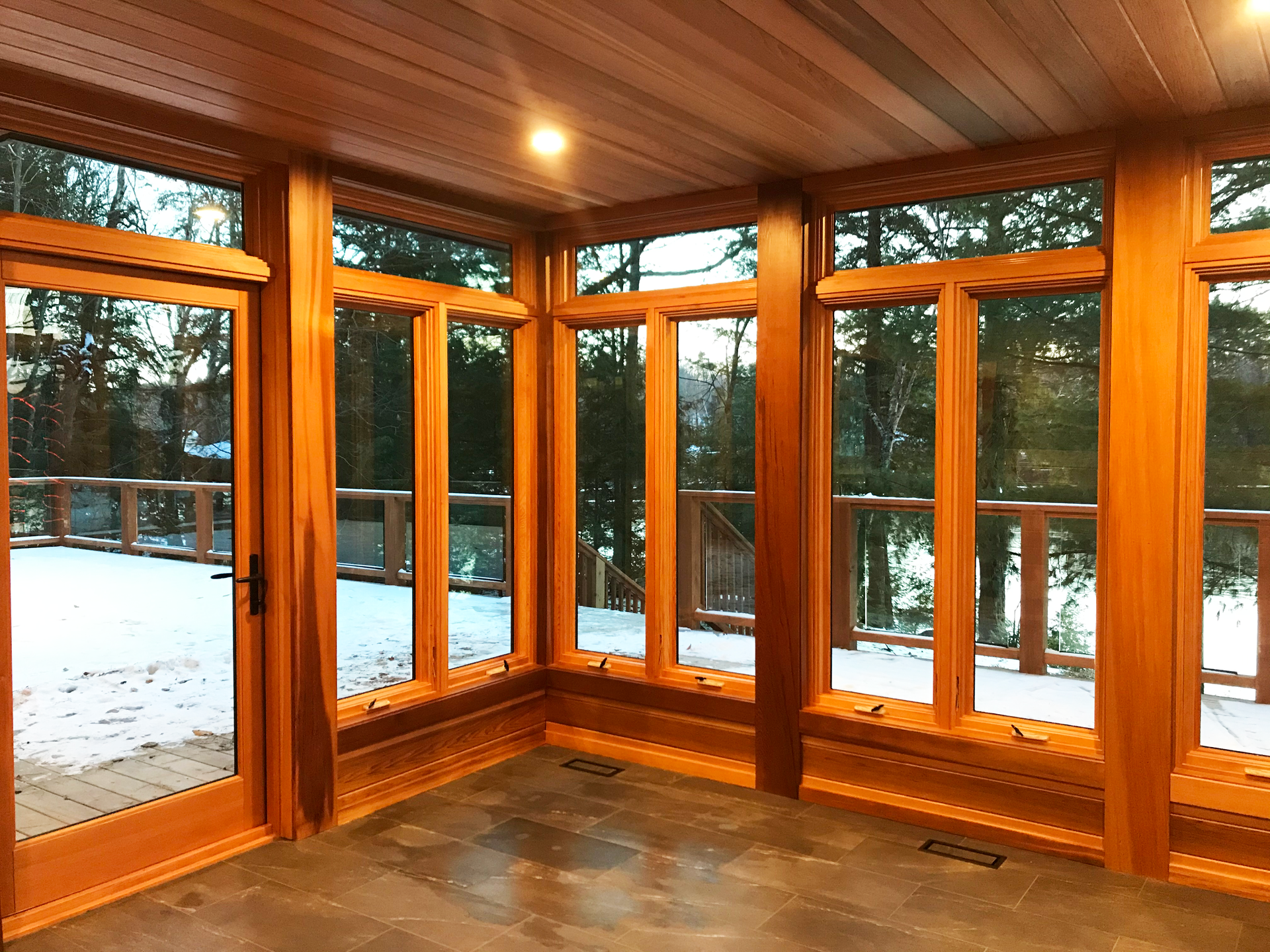 Inside the uncompleted Muskoka Room showing wood ceilings, floors and window fixtures.