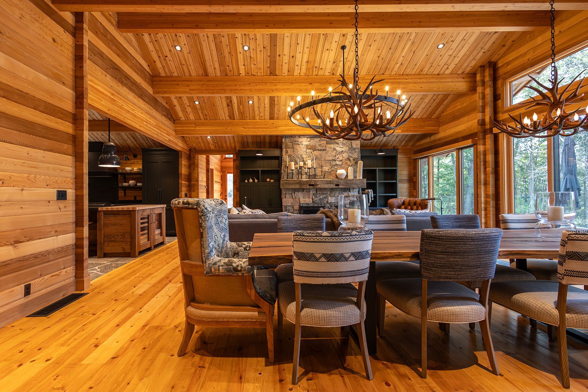 Interior of cedar cottage showing dining room, windows and fireplace beyond.