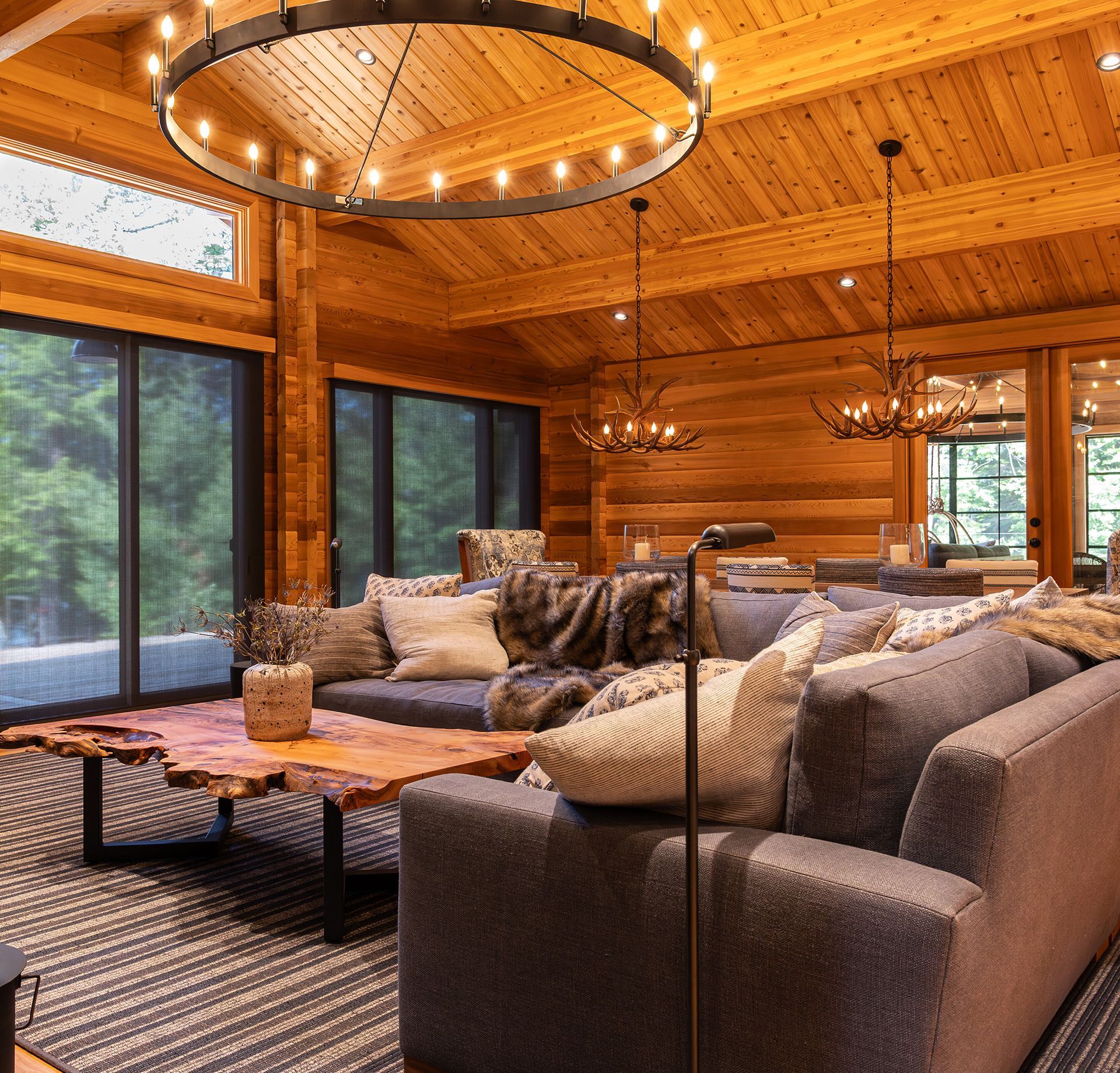 Living room of a cedar cottage with rustic chandelier.
