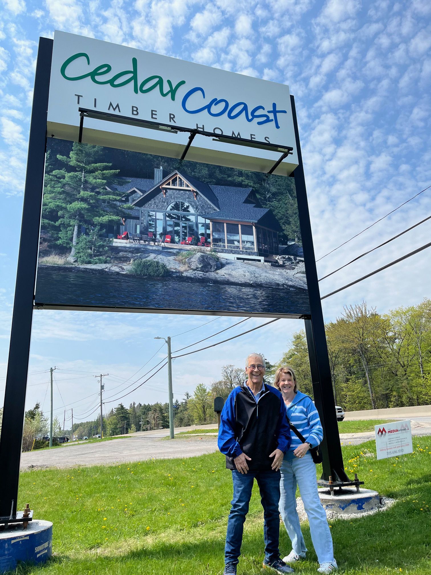Large highway sign for CedarCoast with smiling customers